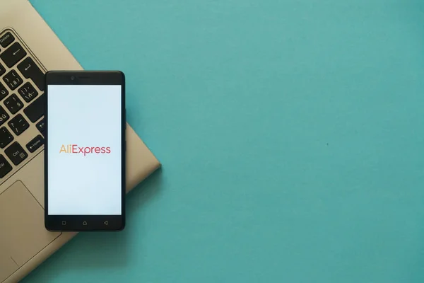 Logotipo de Aliexpress en el smartphone colocado en el teclado portátil . —  Fotos de Stock