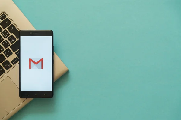 Logo Gmail na smartfonie umieszczone na klawiaturze laptopa. — Zdjęcie stockowe