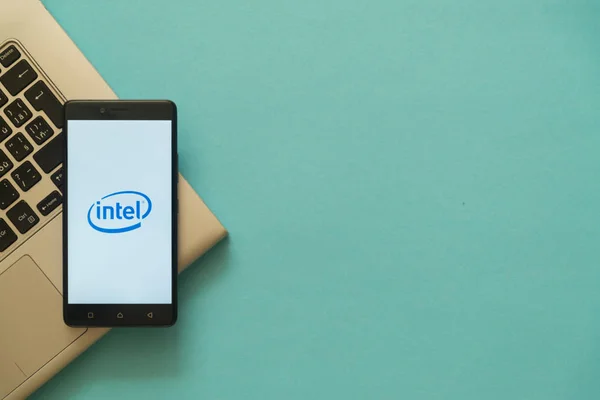 Logo Intel na smartfonie umieszczone na klawiaturze laptopa. — Zdjęcie stockowe