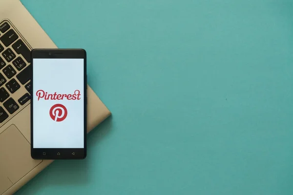 Logotipo Pinterest no smartphone colocado no teclado do laptop . — Fotografia de Stock