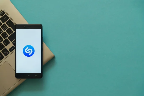 Shazam logó smartphone forgalomba laptop billentyűzet. — Stock Fotó