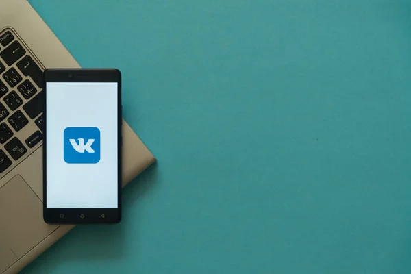 Logotipo Vkontakte no smartphone colocado no teclado do laptop . — Fotografia de Stock