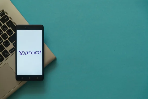 Logotipo de Yahoo en el teléfono inteligente colocado en el teclado portátil . —  Fotos de Stock