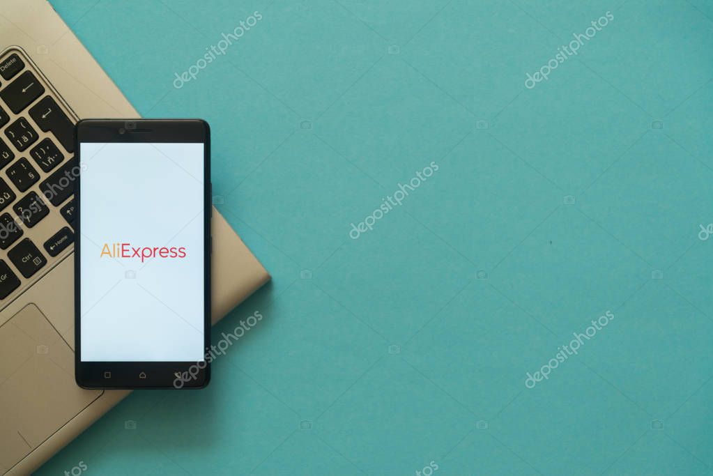 Los Angeles, USA, october 19, 2017: Aliexpress logo on smartphone placed on laptop keyboard. Empty copyscape place on green background to write information.