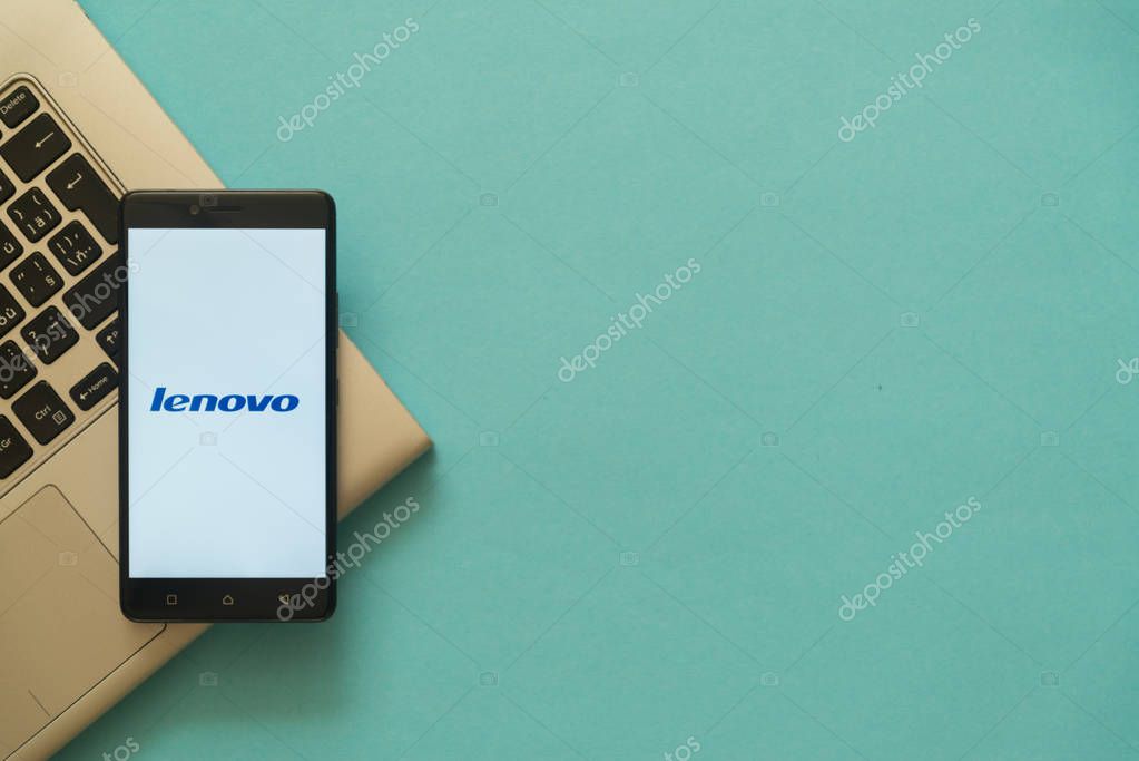 Los Angeles, USA, october 19, 2017: Lenovo logo on smartphone placed on laptop keyboard. Empty copyscape place on green background to write information.