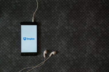 Dropbox logo üstünde smartphone perde metal plaka arka plan üzerinde.