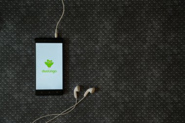 Duolingo logo üstünde smartphone perde metal plaka arka plan üzerinde.