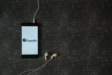 Expedia logo üstünde smartphone perde metal plaka arka plan üzerinde.