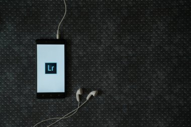 Adobe photoshop lightroom logosu metal plaka arka plan üzerinde smartphone ekranında.