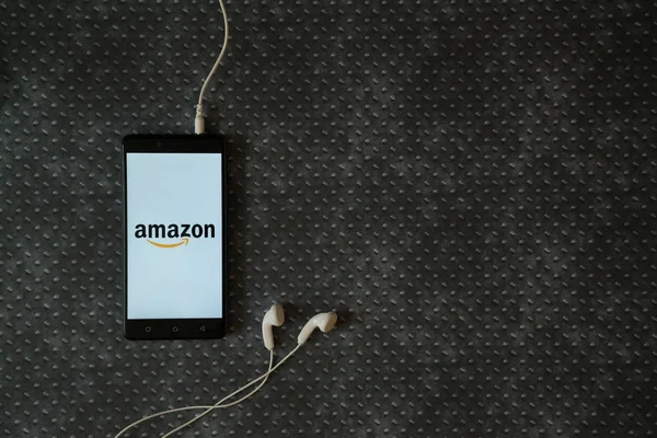 Logotipo de Amazon en la pantalla del teléfono inteligente sobre fondo de placa metálica . — Foto de Stock