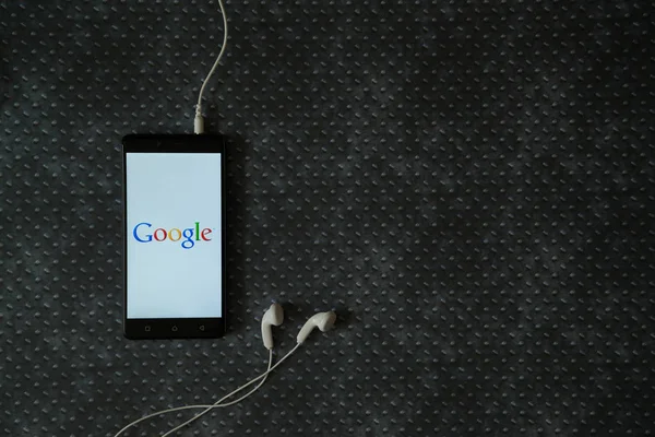 Logo de Google en la pantalla del teléfono inteligente sobre fondo de placa de metal . — Foto de Stock