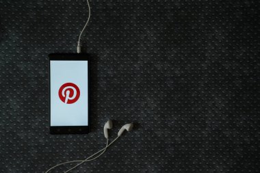 Pinterest logo üstünde smartphone perde metal plaka arka plan üzerinde.