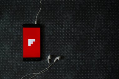 Flipboard logo üstünde smartphone perde metal plaka arka plan üzerinde.