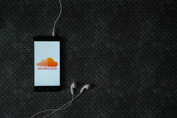 Logotipo Soundcloud na tela do smartphone no fundo da placa de metal . — Fotografia de Stock