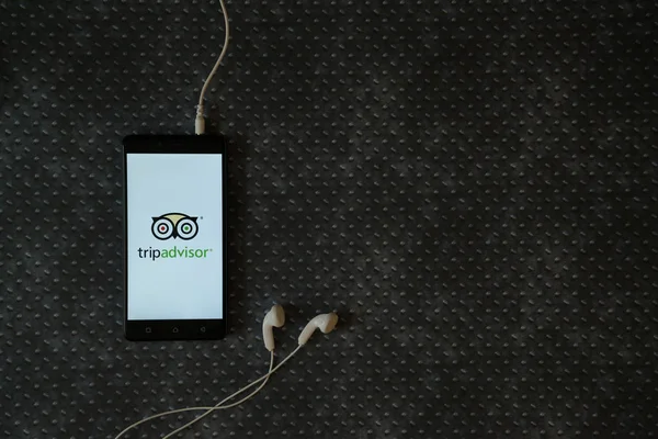 Logotipo do Tripadvisor na tela do smartphone no fundo da placa de metal . — Fotografia de Stock