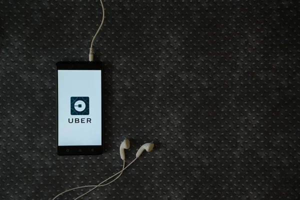 Uber logo üstünde smartphone perde metal plaka arka plan üzerinde.