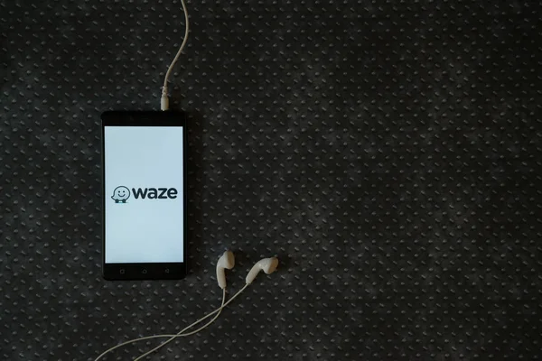 Logo Waze sur l'écran du smartphone sur fond de plaque métallique . — Photo