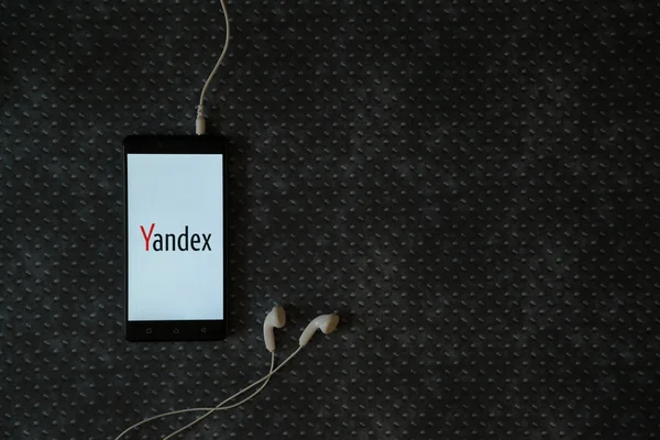 Logotipo de Yandex en la pantalla del teléfono inteligente sobre fondo de placa metálica . — Foto de Stock