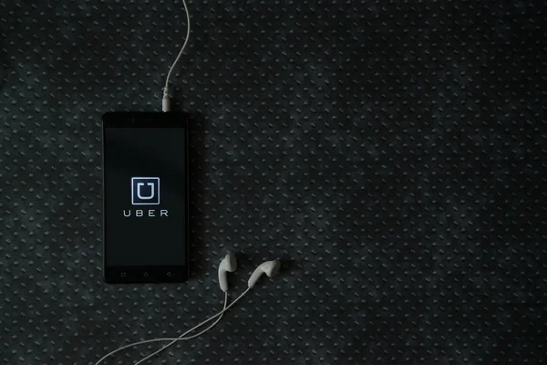 Logotipo Uber na tela do smartphone no fundo da placa de metal . — Fotografia de Stock