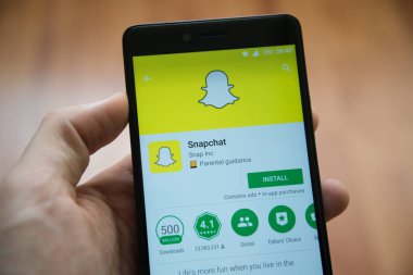 Snapchat uygulaması ile Smartphone google oyun deposunda tutan adam el