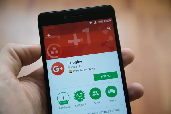 Hombre de la mano del teléfono inteligente con Google plus aplicación en Google Play Store — Foto de Stock