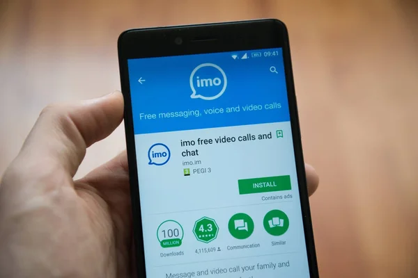 Hombre de la mano del teléfono inteligente con aplicación IMO en Google Play Store —  Fotos de Stock