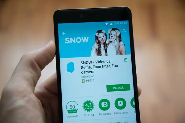 Рука людини проведення смартфон з снігу програми в google play магазин — стокове фото