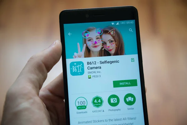 Рука людини проведення смартфон з B612 Selfiegenic застосування камери в google play магазин — стокове фото