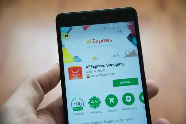 Adam el smartphone Aliexpress uygulaması ile google oyun deposunda tutarak — Stok fotoğraf