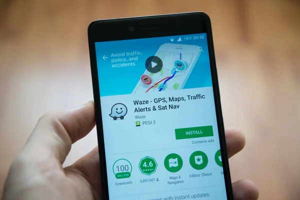 Man hand holding smartphone with Waze application in google play store — Stock Photo, Image