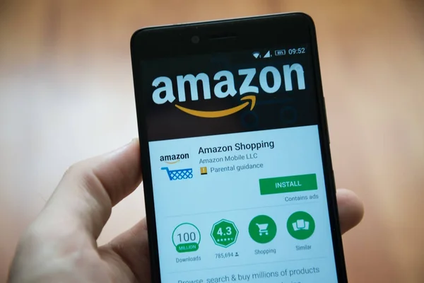 Hombre de la mano del teléfono inteligente con Amazon aplicación de compras en Google Play Store — Foto de Stock