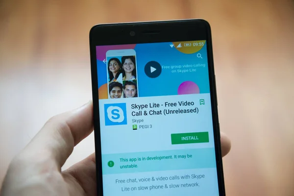 Рука людини проведення смартфон за допомогою Skype lite unreleased програми в google play магазин — стокове фото