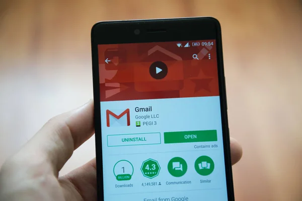 Рука людини проведення смартфон з Gmail додатків в google play магазин — стокове фото