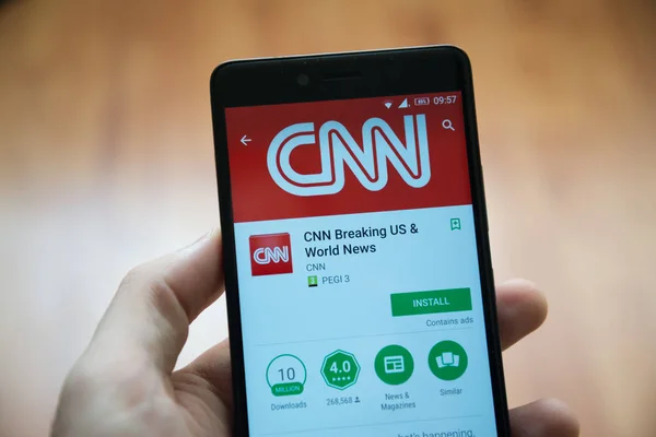 Homem mão segurando smartphone com aplicação CNN na loja google play — Fotografia de Stock