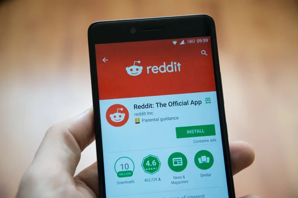 Los angeles, 2. November 2017: Mann hält Smartphone mit Reddit-Anwendung im google play store — Stockbild Mann hält Smartphone mit Reddit-Anwendung in Google Play Store — Stockfoto