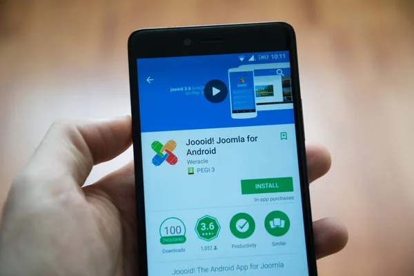 Людина ручної проведення смартфон з Joooid, Joomla для android додатків у Гуглі грати магазин — стокове фото