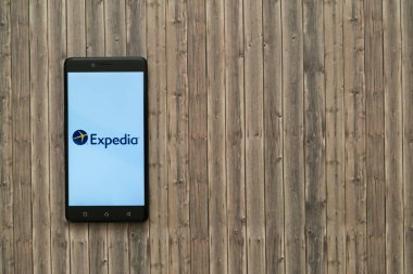 Expedia logo üstünde smartphone perde ahşap arka plan üzerinde.