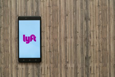 Lyft logo üstünde smartphone perde ahşap arka plan üzerinde.