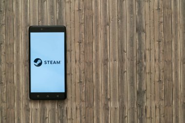 Buhar logo üstünde smartphone perde ahşap arka plan üzerinde.
