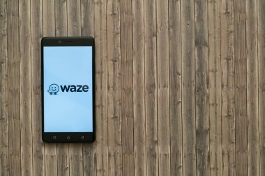 Waze logo üstünde smartphone perde ahşap arka plan üzerinde.