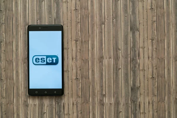 Logotipo de Eset en pantalla de teléfono inteligente sobre fondo de madera . — Foto de Stock