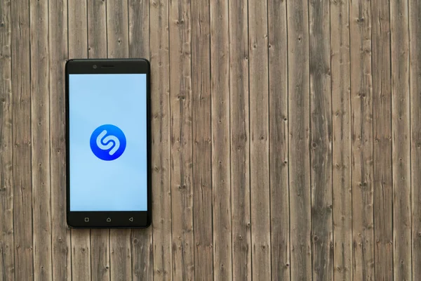 Logo de Shazam en la pantalla del teléfono inteligente sobre fondo de madera . — Foto de Stock