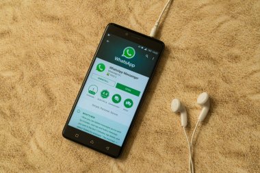 Whatsapp uygulama Google oyun deposu kumlu arka plan ve kulaklıklar üzerinde