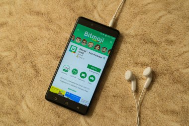 Bitmoji uygulama Google oyun deposu kumlu arka plan ve kulaklıklar üzerinde