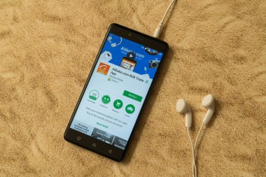 Alibaba.com uygulama Google oyun deposu kumlu arka plan ve kulaklıklar üzerinde