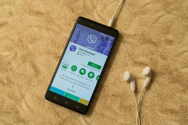 Aplicación Viber en Google Play Store sobre fondo arenoso y auriculares — Foto de Stock
