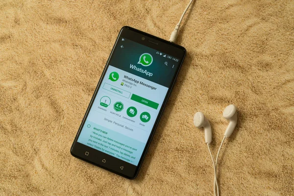 Εφαρμογή WhatsApp στο google Παίξτε κατάστημα στην αμμουδιά παρασκηνίου και ακουστικά — Φωτογραφία Αρχείου