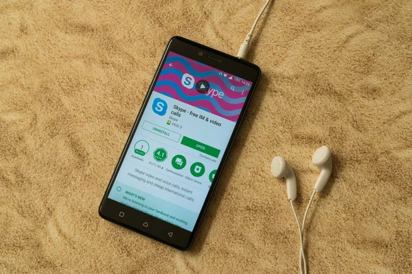 Aplicación de Skype en Google Play Store en fondo arenoso y auriculares — Foto de Stock