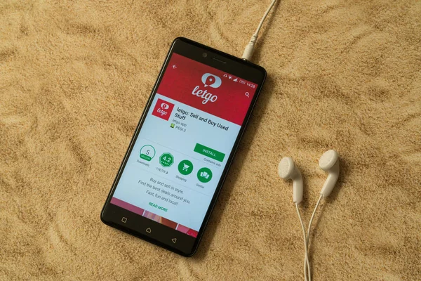 Aplicación Letgo en Google Play Store sobre fondo arenoso y auriculares — Foto de Stock