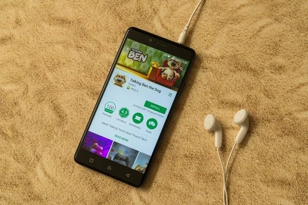 Talking ben the dog application in google play store auf sandigem Hintergrund und Kopfhörer — Stockfoto